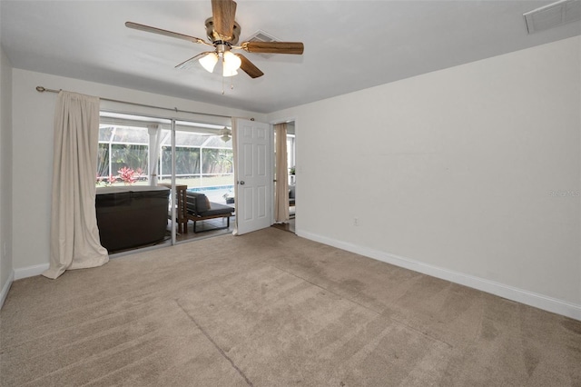 carpeted empty room featuring a ceiling fan and baseboards