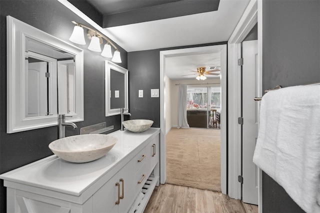 bathroom featuring wood finished floors, double vanity, and a ceiling fan