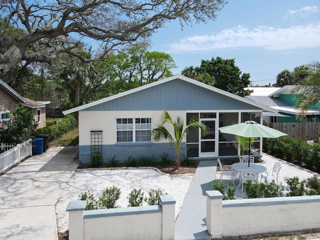 106 E Cedar St, Tarpon Springs, FL 34689 - view of front of property featuring a fenced front yard, a sunroom, and stone siding