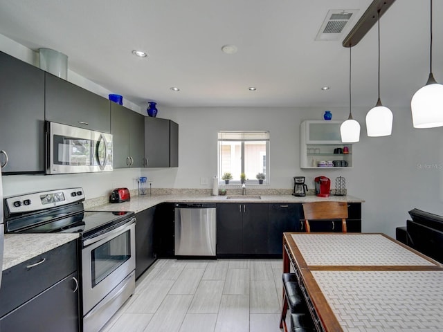 106 E Cedar St, Tarpon Springs, FL 34689 - kitchen featuring stainless steel appliances, light countertops, a sink, pendant lighting, and recessed lighting