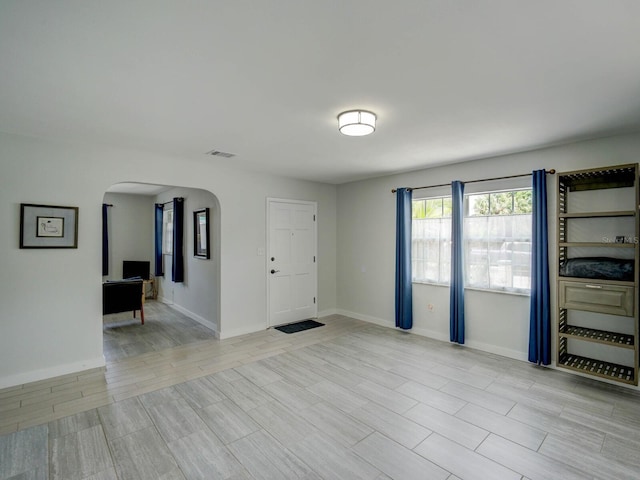 106 E Cedar St, Tarpon Springs, FL 34689 - unfurnished room featuring arched walkways, baseboards, and light wood-type flooring