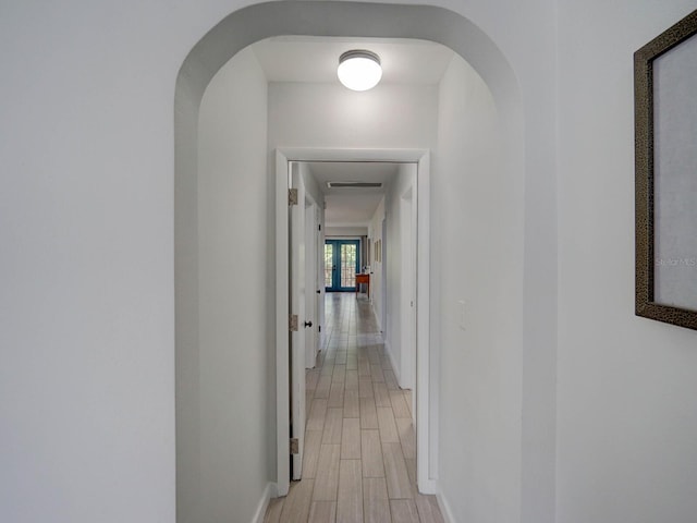 106 E Cedar St, Tarpon Springs, FL 34689 - hallway with baseboards, arched walkways, and light wood-style flooring