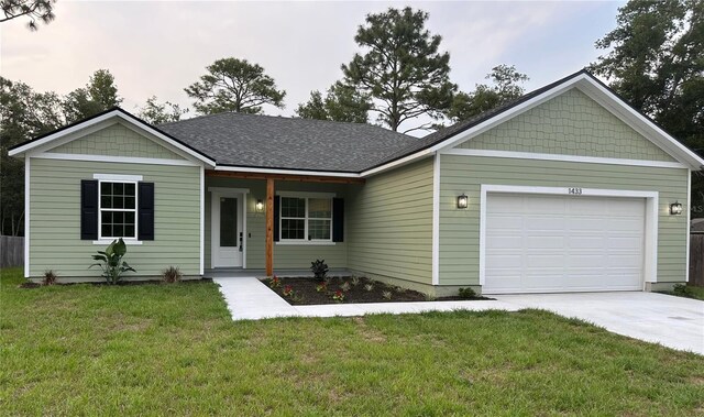 ranch-style home with driveway, a front yard, and a garage
