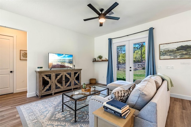 living room with ceiling fan, baseboards, wood finished floors, and french doors