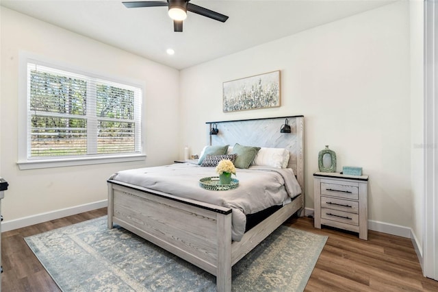 bedroom featuring baseboards, wood finished floors, and a ceiling fan