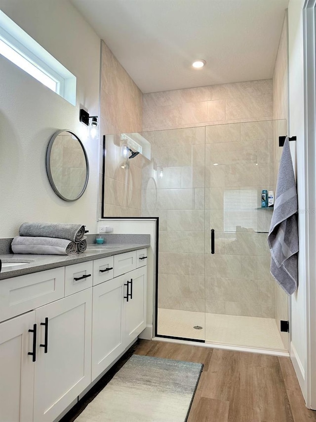 full bath featuring wood finished floors, vanity, and a shower stall
