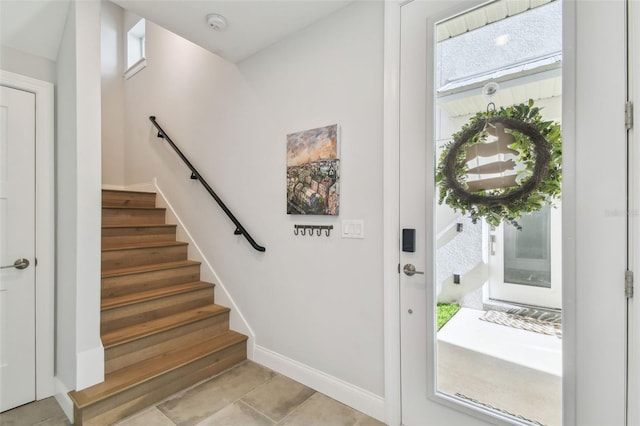entrance foyer featuring stairs and baseboards