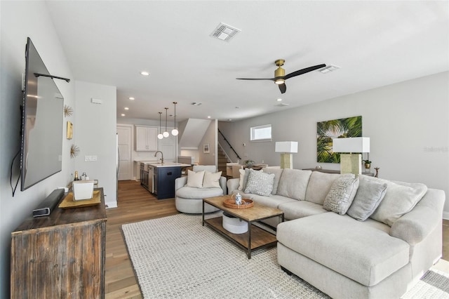 living area with wood finished floors, stairs, recessed lighting, a ceiling fan, and baseboards