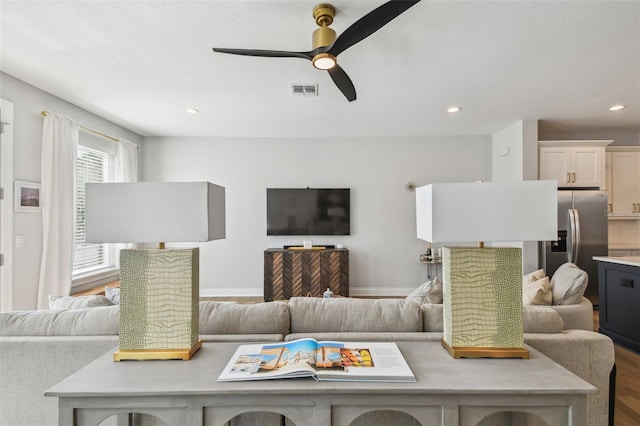 living area with wood finished floors, ceiling fan, recessed lighting, and baseboards