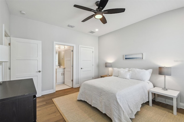 bedroom featuring wood finished floors, baseboards, recessed lighting, ensuite bathroom, and a ceiling fan
