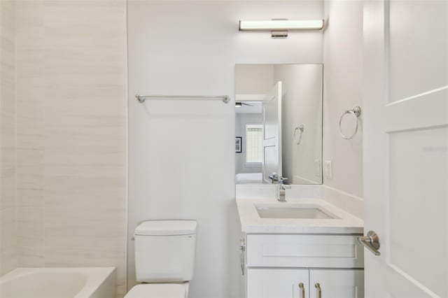 bathroom featuring toilet, vanity, and washtub / shower combination