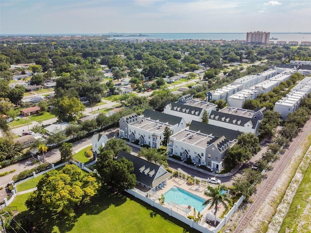drone / aerial view of a pool and a large body of water