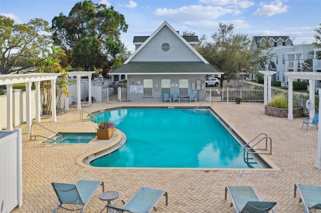 community pool with a pergola, fence, and a hot tub