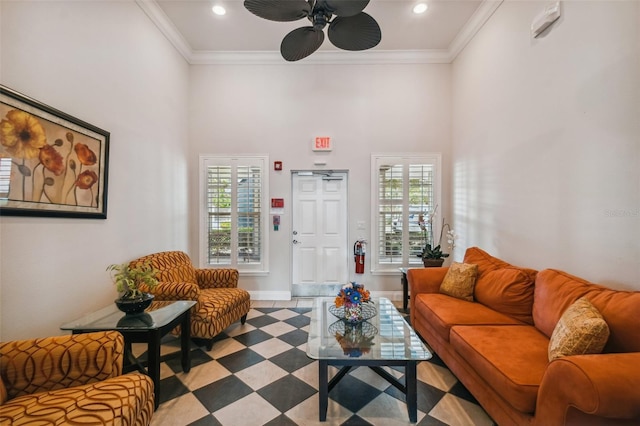 living room featuring plenty of natural light, ceiling fan, baseboards, tile patterned floors, and a high ceiling