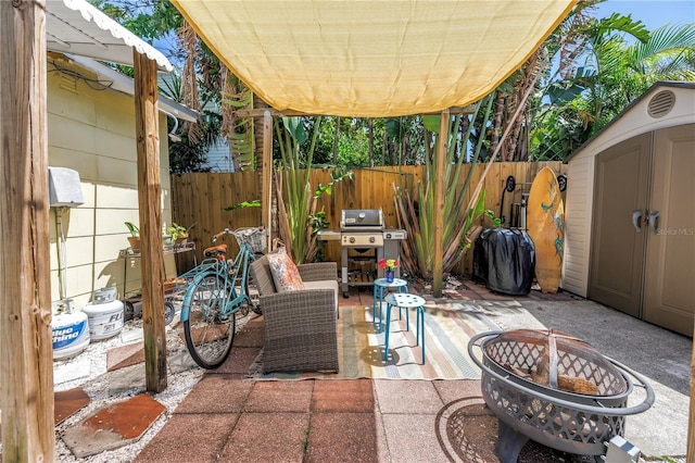 1038 Crescent Lake Dr N, Saint Petersburg, FL 33701 - view of patio / terrace with a fire pit, a storage unit, an outdoor structure, area for grilling, and fence