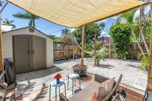1038 Crescent Lake Dr N, Saint Petersburg, FL 33701 - view of patio / terrace with an outdoor fire pit, a storage shed, a fenced backyard, and an outdoor structure