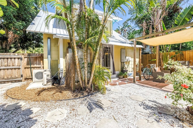 1038 Crescent Lake Dr N, Saint Petersburg, FL 33701 - rear view of house with a patio area, fence, metal roof, and ac unit