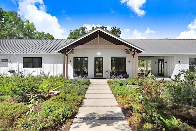 view of front of home with metal roof, a standing seam roof, ceiling fan, and board and batten siding