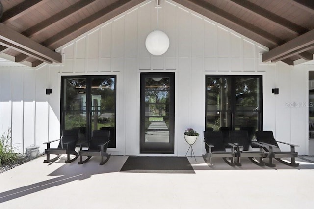 doorway to property with board and batten siding and a patio