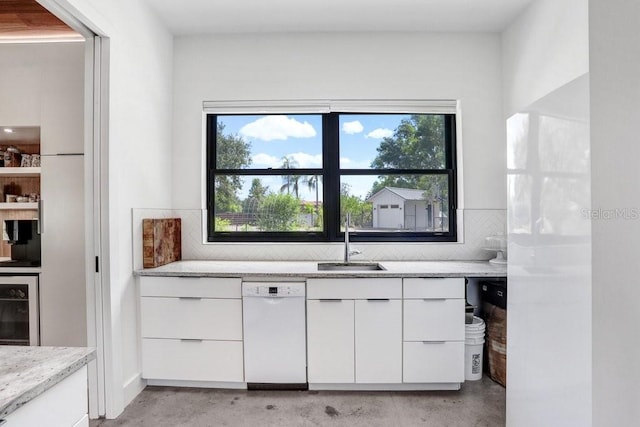 kitchen featuring a sink, dishwasher, concrete flooring, and beverage cooler