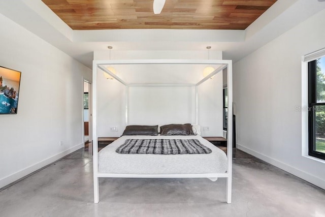 bedroom featuring wooden ceiling, finished concrete floors, baseboards, and a tray ceiling