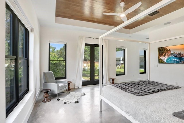 bedroom with a raised ceiling, finished concrete floors, wood ceiling, and french doors