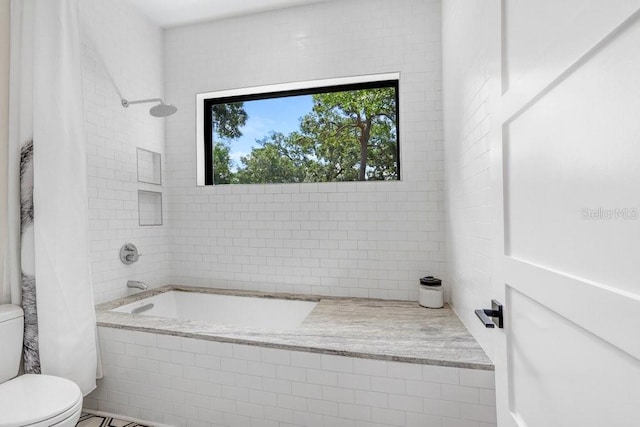 full bathroom with toilet and tiled shower / bath