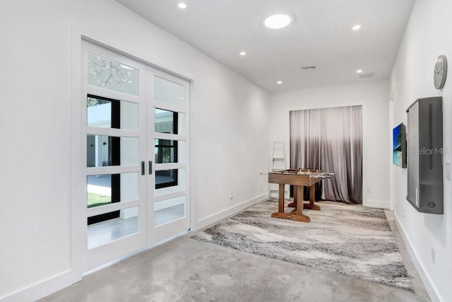 doorway to outside with concrete floors, plenty of natural light, recessed lighting, baseboards, and french doors