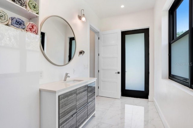 bathroom featuring marble finish flooring, baseboards, vanity, and recessed lighting