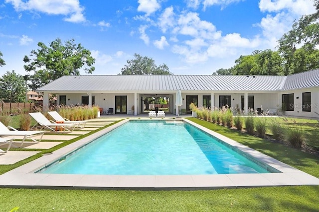 outdoor pool with a patio and a yard