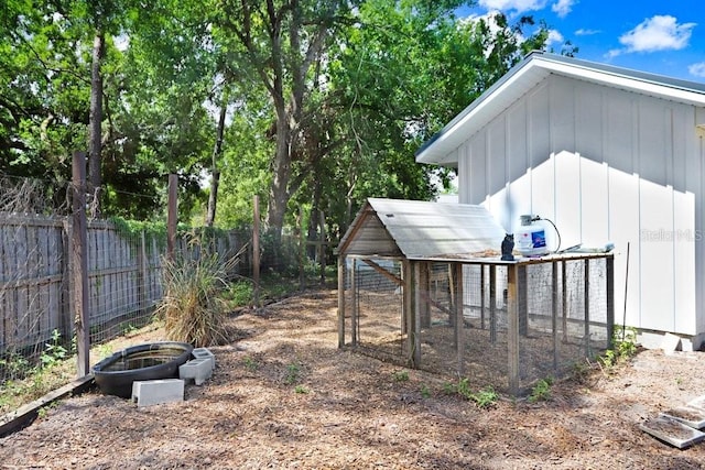 view of yard featuring exterior structure, fence, and an outdoor structure