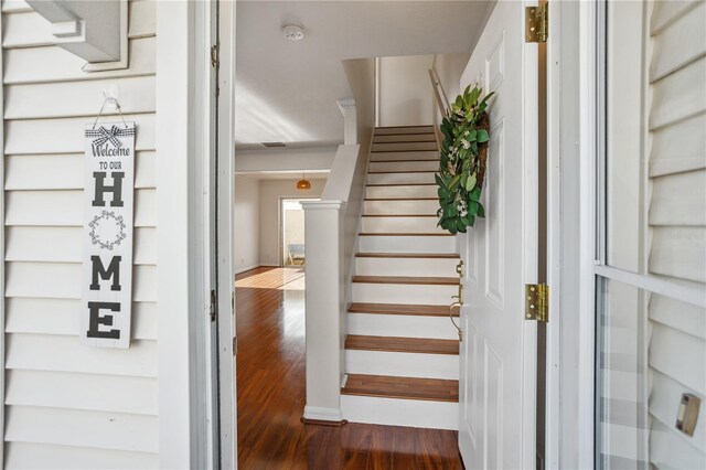 staircase featuring wood finished floors and baseboards