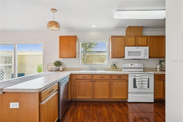 kitchen featuring white appliances, a sink, a peninsula, light countertops, and ornamental molding