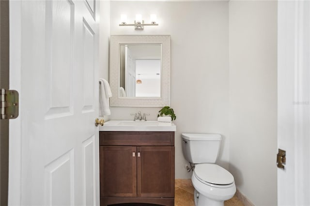 bathroom with toilet, vanity, and tile patterned flooring