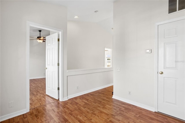 spare room featuring ceiling fan, wood finished floors, baseboards, and lofted ceiling