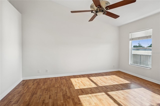 empty room with wood finished floors, baseboards, a ceiling fan, and lofted ceiling