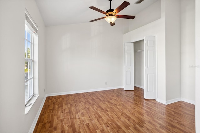 unfurnished bedroom with light wood-type flooring, baseboards, a closet, and a ceiling fan