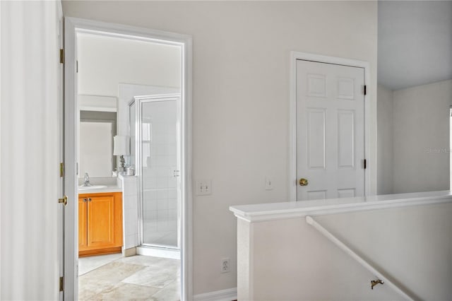 bathroom with a shower stall, vanity, and baseboards