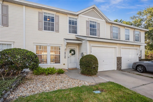multi unit property featuring an attached garage and concrete driveway