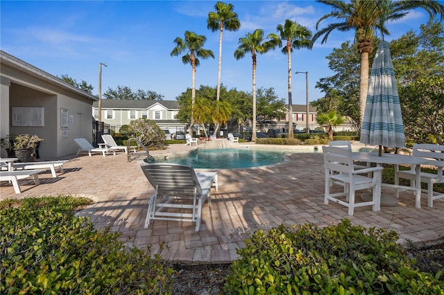 community pool featuring a patio area and fence