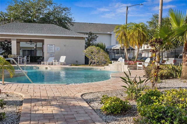 community pool featuring ceiling fan, a patio, and fence