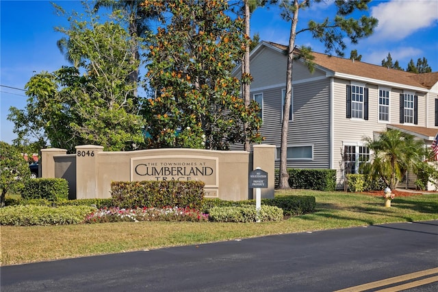 community / neighborhood sign featuring a yard