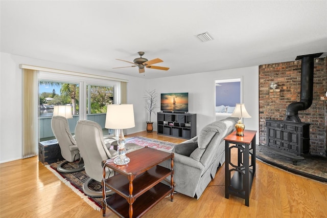 261 Kentucky Ave, Crystal Beach, FL 34681 - living area featuring a ceiling fan, wood finished floors, a wood stove, and baseboards