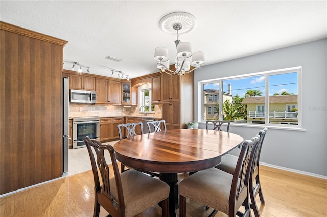 261 Kentucky Ave, Crystal Beach, FL 34681 - dining space featuring a chandelier, baseboards, healthy amount of natural light, and track lighting