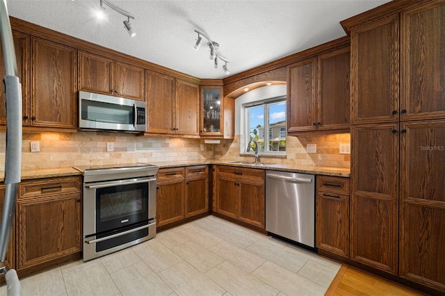 261 Kentucky Ave, Crystal Beach, FL 34681 - kitchen featuring stainless steel appliances, a sink, light stone counters, and tasteful backsplash