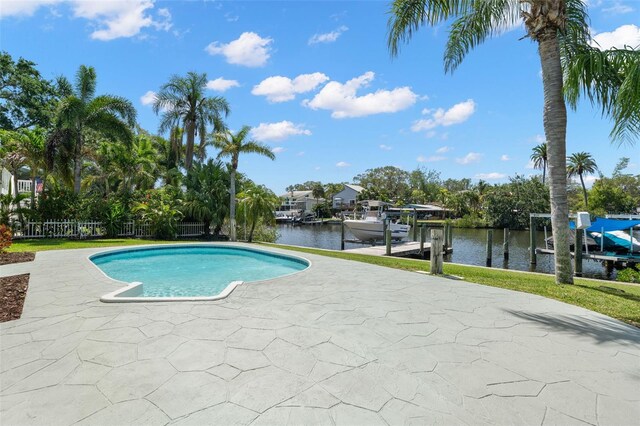 261 Kentucky Ave, Crystal Beach, FL 34681 - outdoor pool featuring boat lift, a boat dock, a water view, a patio area, and fence