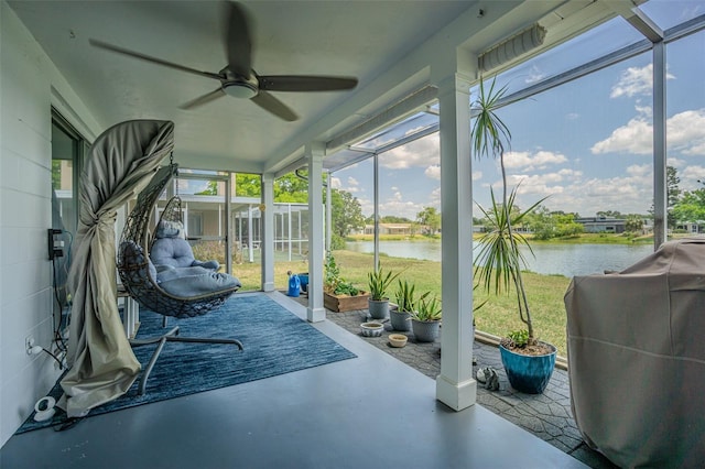 sunroom / solarium with ceiling fan and a water view