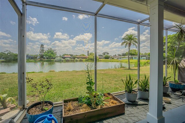 sunroom featuring a water view