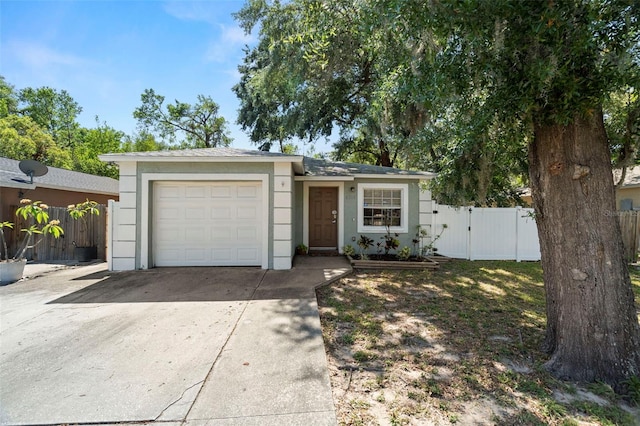 6208 Rolling Hammock, Tampa, FL 33610 - view of front of house featuring concrete driveway, a garage, fence, a gate, and stucco siding
