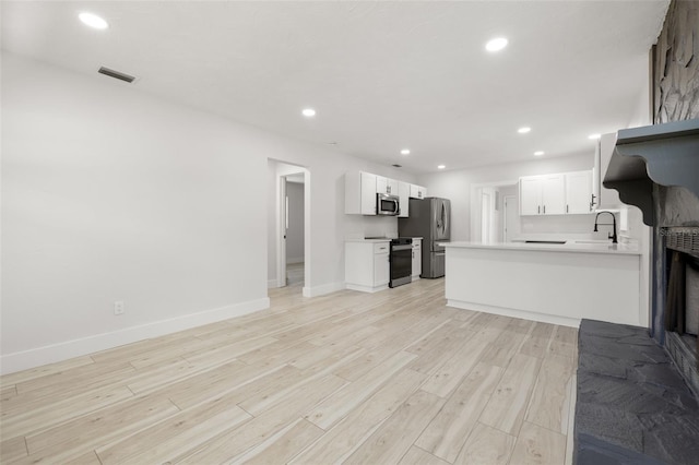 2157 20th Ave SW, Largo, FL 33774 - unfurnished living room with a sink, light wood-style floors, baseboards, and recessed lighting